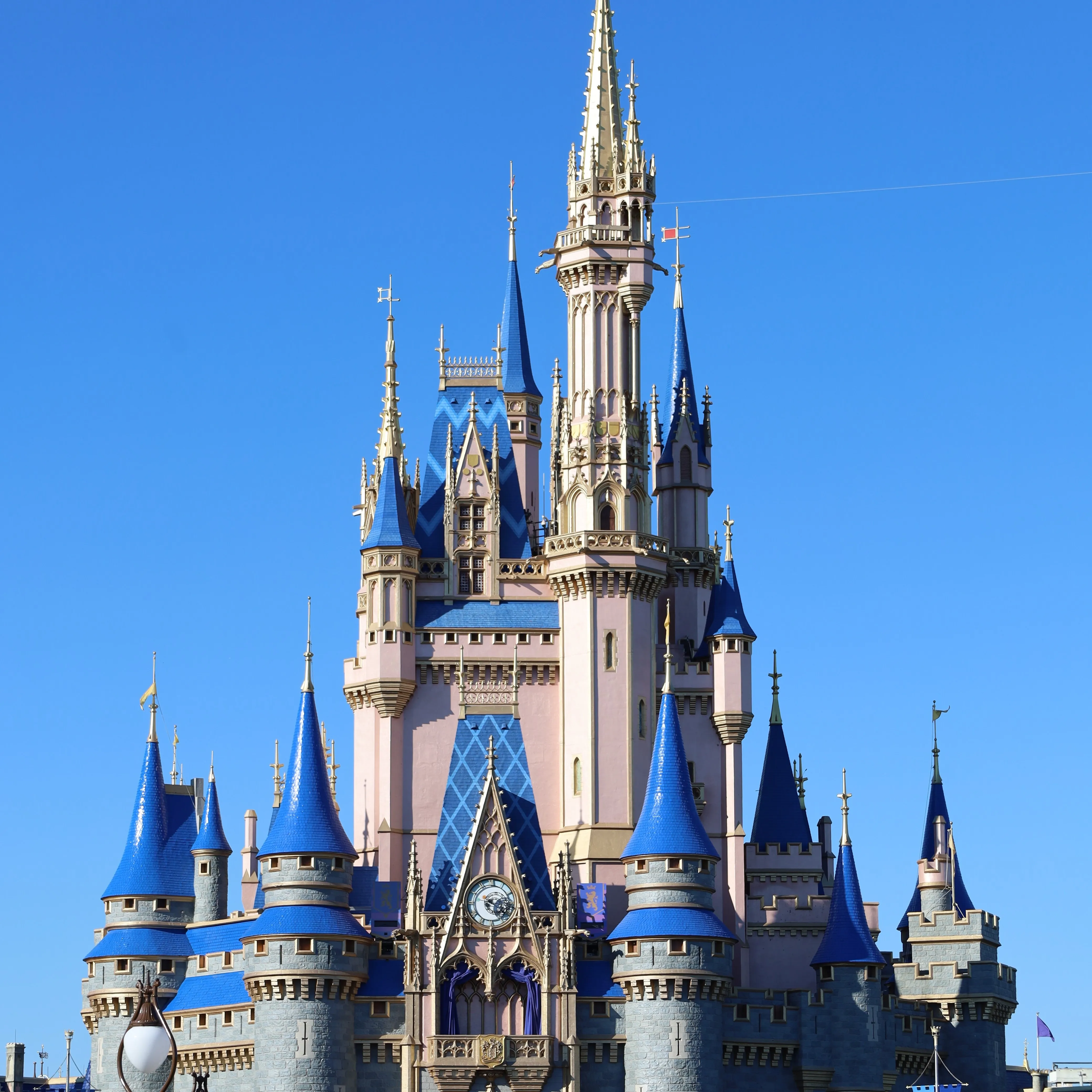 Cinderella Castle at Magic Kingdom beneath a vivid blue sky
